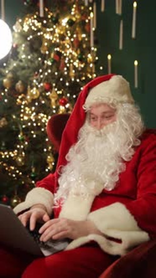 Santa Claus Sits Quietly in an Armchair Beside the Christmas Tree Vertical Video