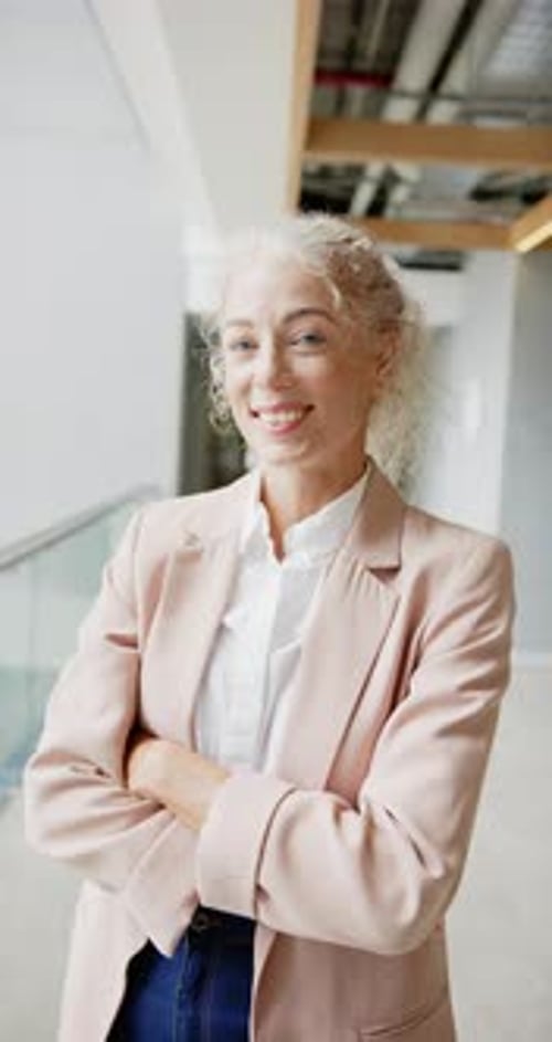 Smiling Woman with Gray Hair and Pink Blazer