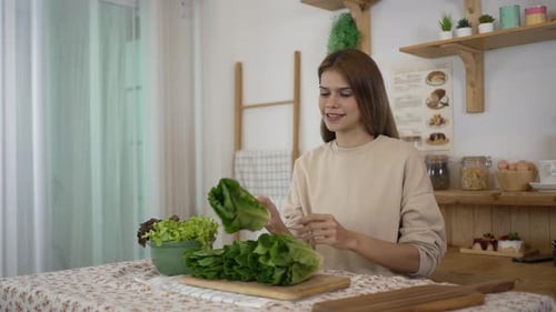Woman Prepares Healthy Lettuce in Bright Kitchen