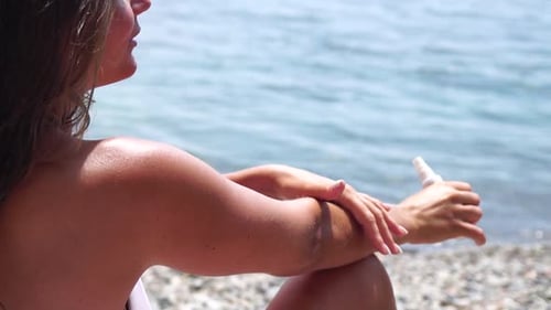 Woman Sunscreen Sea Happy Lady Applies Sunblock Cream on Tanned Skin Before Sunbathing Female On Sea