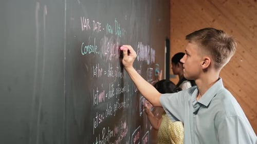 Seitenansicht eines Jungen, der mit verschiedenen Freunden Code an die Tafel schreibt. Erbauung
