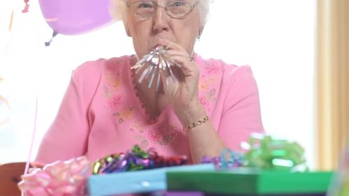 Senior Woman Smiling with Balloons and Party Horn