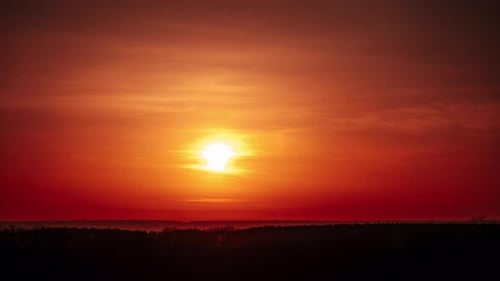 Timelapse of Dramatic Sunset Through Clouds in the Orange Sky Over the Horizon