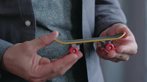 Hands Holding Miniature Skateboard Toy Close Up