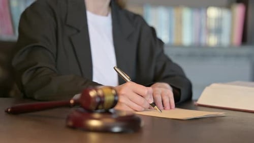 Close Up of Young Judge Writing Verdict in Court