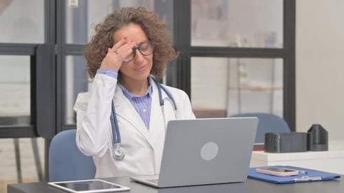 Hispanic Female Doctor having Headache in Hospital
