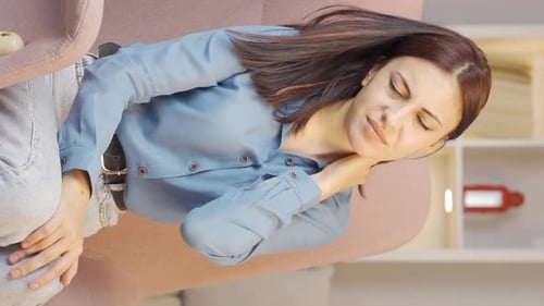 Woman Experiencing Neck Pain While Sitting Down