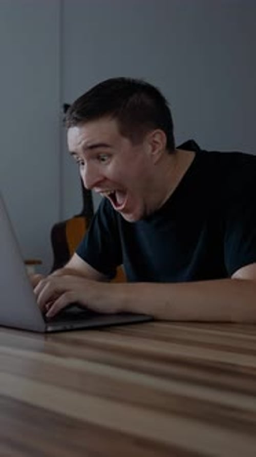 Man Working on Laptop Celebrates Good News