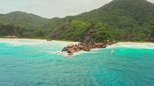 Cinematic Aerial Drone Shot of Beautiful Turquoise Sea and Rocky Deserted Beach on Tropical Island.
