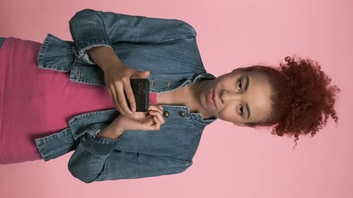 Vertical Portrait of African American Woman Using Smartphone Connecting with Colleagues Over