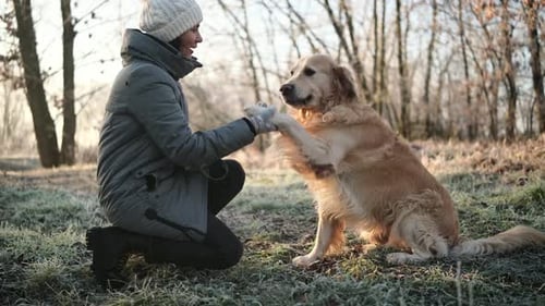 Woman Petting Dog in a Frosty Winter Landscape