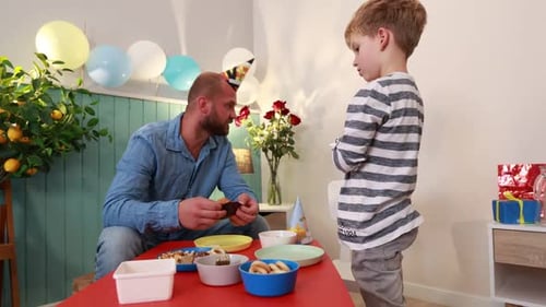 Dad and Son Celebrating a Birthday at Home