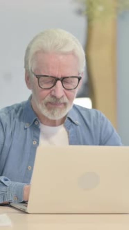 Senior Man Giving a Thumbs Up at Laptop