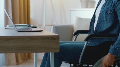 Man in Wheelchair Working from Home on Laptop