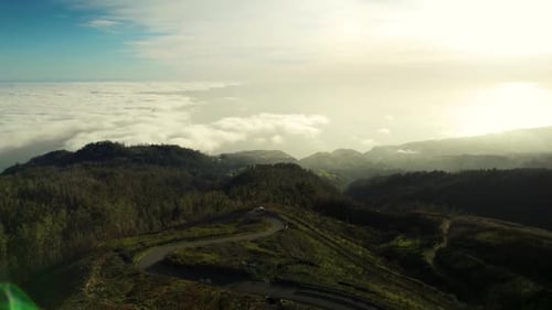 Drone Footage of a Scenic Curvy Road Winding Above the Clouds