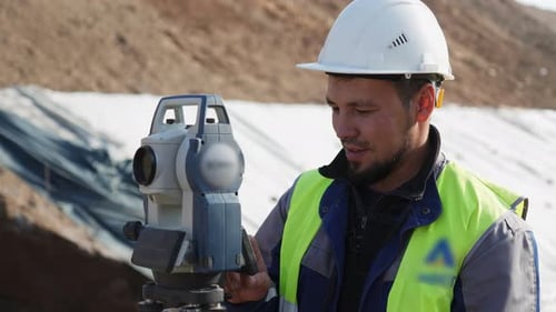Vermessungsingenieur verwendet Theodolit auf einer Baustelle — Clip
