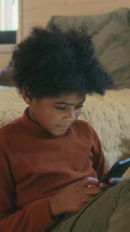 Smiling Child Using Smartphone Indoors