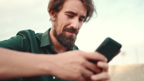 Close-up of smiling man chatting on the embankment background
