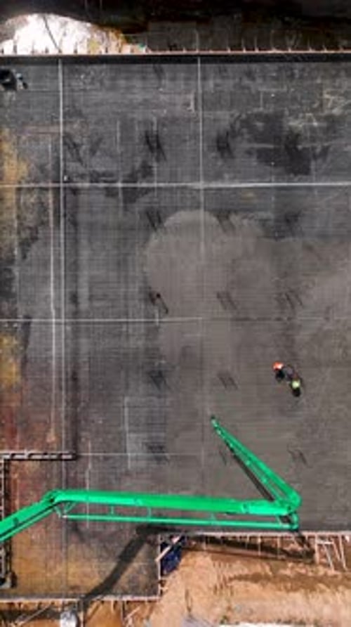 Vidéo verticale de construction active montrant le coulage du béton et l'assemblage du métal avec