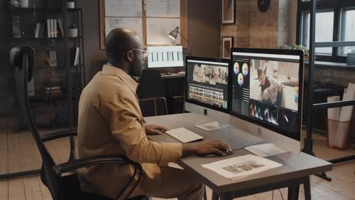 Afroamerikanischer Redakteur, der mit Project Cuts am Computer arbeitet