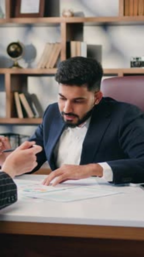 Two Business Multiracial Partners Discussing Documents in Office Businesswoman and Man Having a