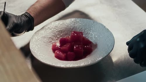 Placing Tuna Pieces with Chopsticks on Plate before Serving in Restaurant