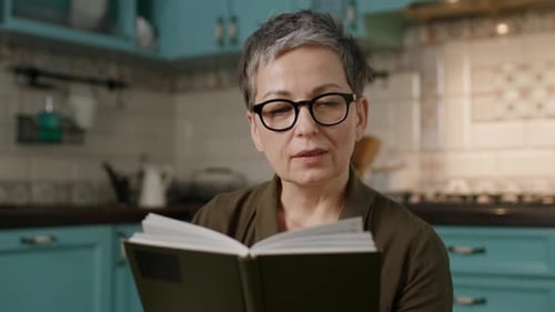Senior Woman Reading Book at Home CloseUp