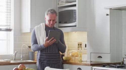 Man Using Tablet for Recipe in Kitchen