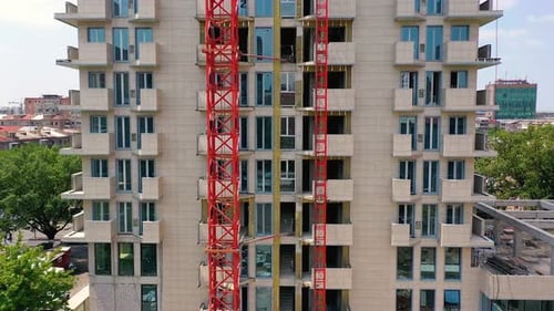 Baufortschritt eines modernen Gebäudes mit Kran und Gerüst im Stadtgebiet.