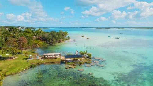 Rive de la lagune de Bacalar avec jetées et bateaux sur des eaux turquoises peu profondes au Mexique