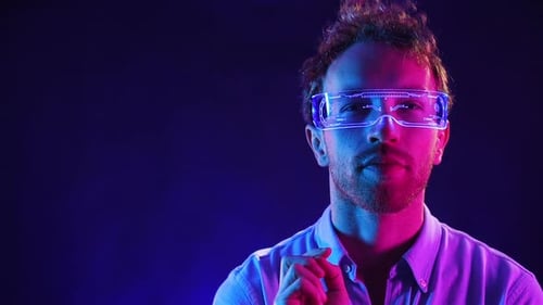 Young man is in the studio with blue neon lighting