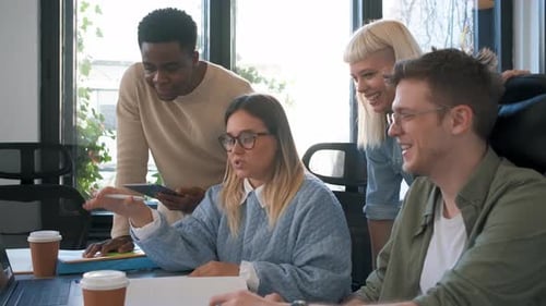 Diverse group of young business people working on new project together in office.