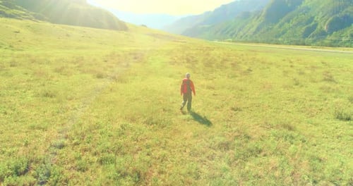 Flight Over Backpack Hiking Tourist Walking Across Green Mountain Field Huge Rural Valley at Summer