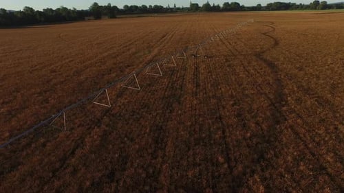 Irrigation equipment sprays water on crops in Oregon field at sunrise