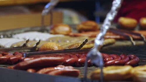 Hot Dogs and Buns Cooking on Grill