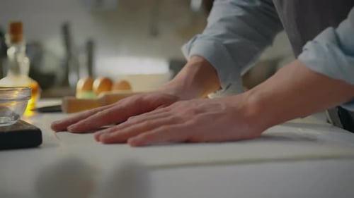 Person Rolling and Folding Dough in Kitchen