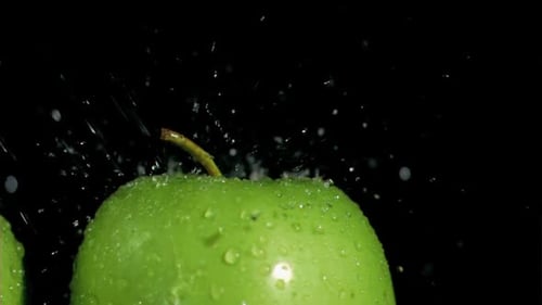 Slow Motion Water Splash on a Crisp Green Apple