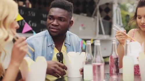 Friends Enjoying Takeout Food Near Food Truck