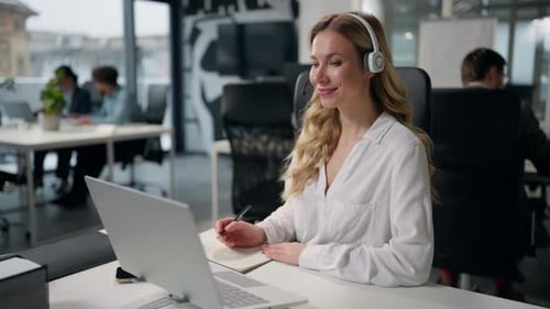 Business Woman in Office Talking with Laptop