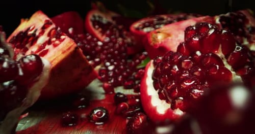 Super-Makro-Diaaufnahme eines Granatapfels auf einer Holzbank in Zeitlupe. Konzept: Essen, Obst, Nass