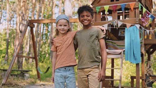 Happy Children Smiling by Treehouse and Swing Set