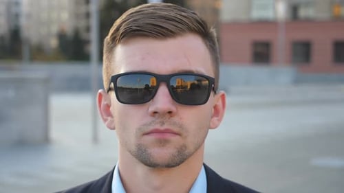 Young Adult Man with Sunglasses Gazing Seriously