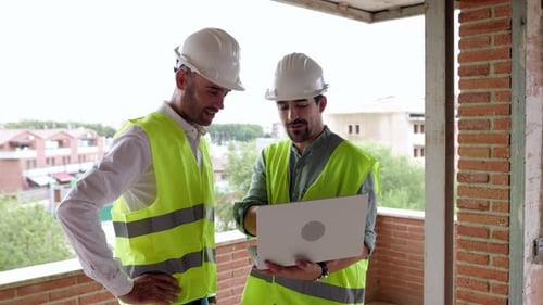 Two Young Architects Male Working Together at Construction Site