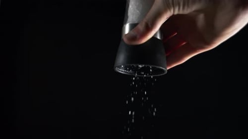 Molino de sal sobre fondo negro 4K