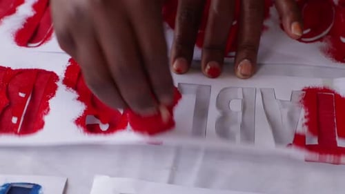 Applying Red Dye to Stenciled Lettering