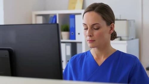Medicine, Technology and Healthcare Concept - Female Doctor or Nurse with Computer
