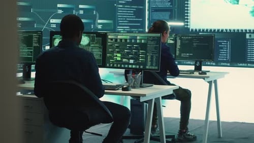 Workers at Desks Work with Cybersecurity Technology