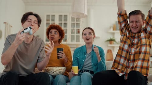 Company of Multiethnic Friends Play Video Games at Home