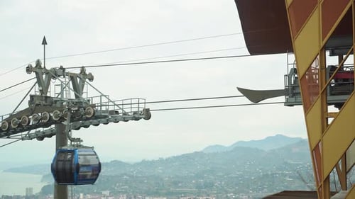 The cabin of the funicular rises along the cable above the city against the background