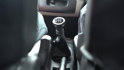 Homem trocando os travões manuais em um carro do banco traseiro cinematográfico.